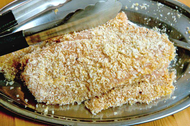 Coat each piece of chicken with the beaten egg, followed by the breadcrumb mixture. 